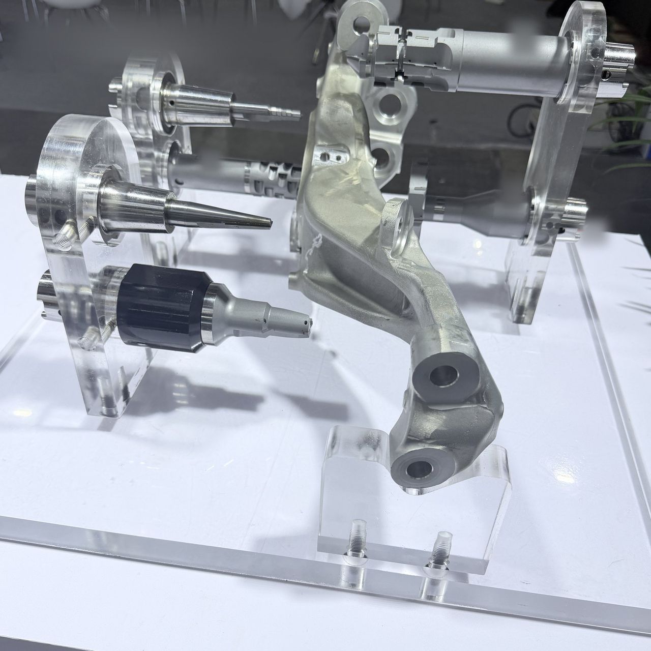 PCD boring and milling tools beside a cast aluminium steering knuckle